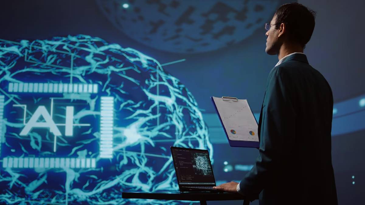 A person in a suit stands before a digital display featuring a glowing neural network with AI prominently displayed. A laptop and clipboard are on a table.