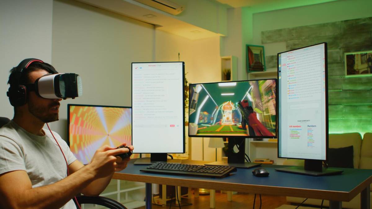 A gamer in a headset holds a controller, surrounded by multiple monitors displaying gameplay and chat. The room is softly lit with green accents.