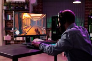 A gamer in a headset plays a futuristic shooter on a vibrant monitor, surrounded by colorful ambient lighting.